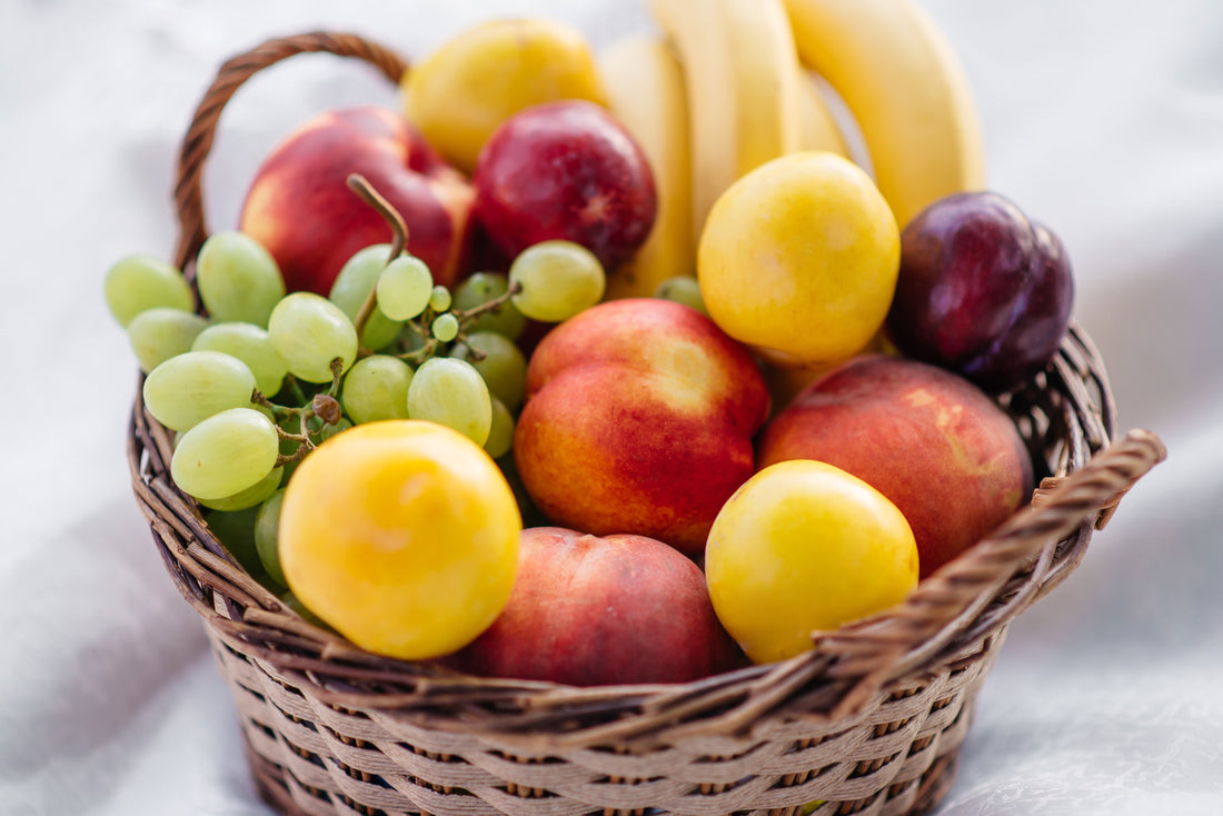 Fresh fruit basket filled with apples, grapes, bananas and citrus, representing healthy food hampers in Singapore for thoughtful gifting.
